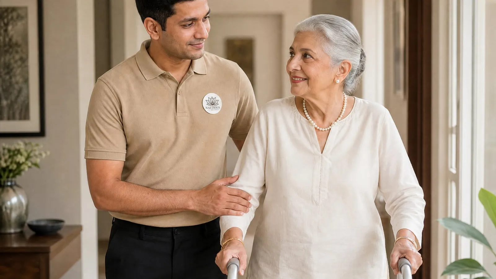 A Naetrika caregiver assisting an elderly woman with a walker during recovery at home