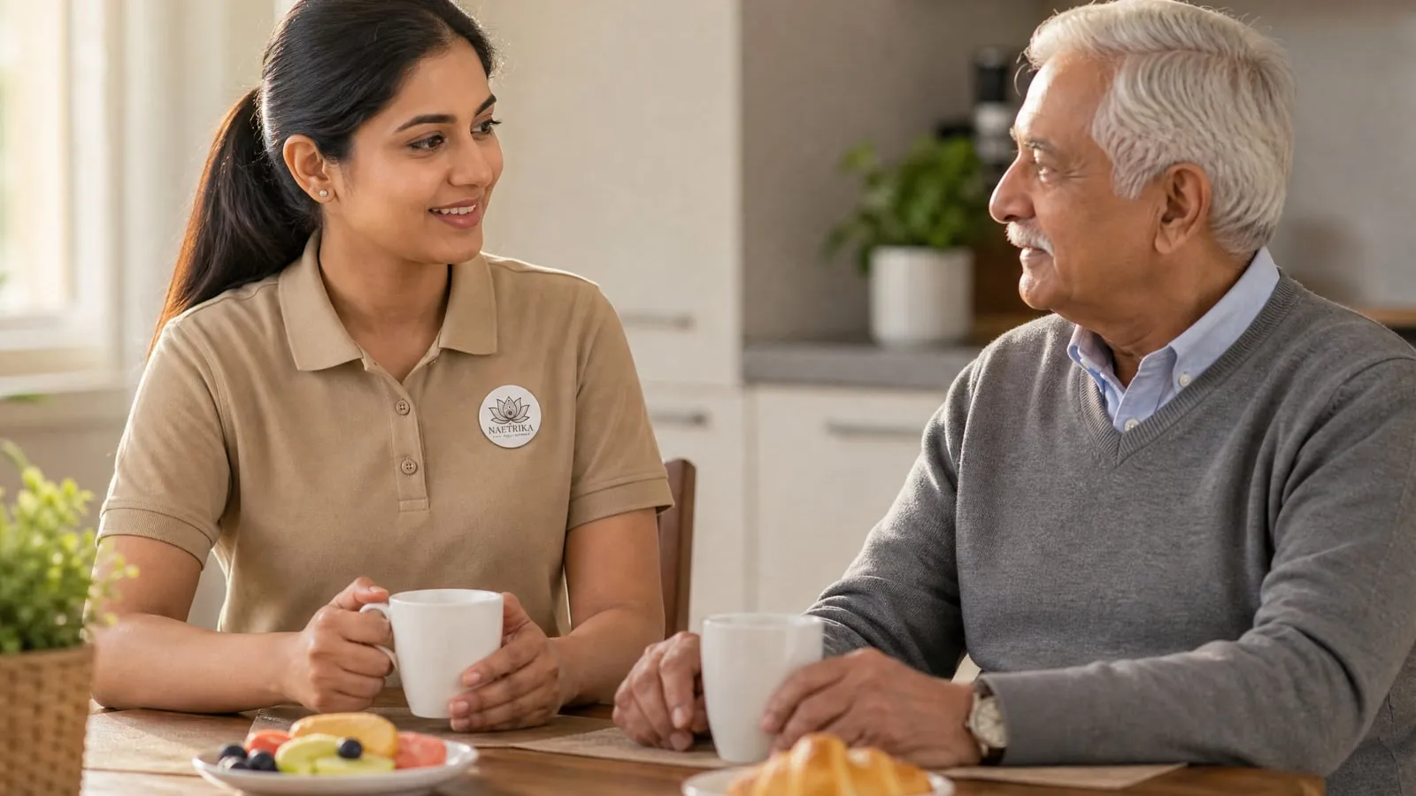 A Naetrika caregiver sharing breakfast and conversation with an elderly man at home